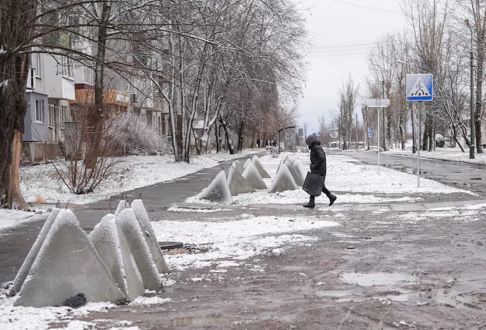 Жінка переходить вулицю на тлі нападу Росії на Україну в місті Покровськ Донецької області, Україна, 12 грудня 2024 року